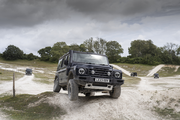INEOS Grenadier tackling uneven terrain with one wheel airborne.